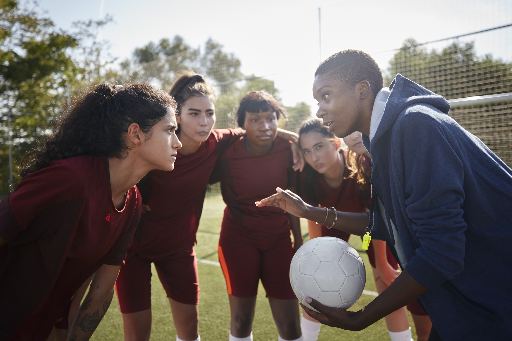 Soccer team and coach in a huddle